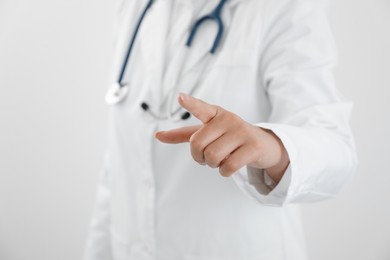 Doctor pointing at something on white background, closeup