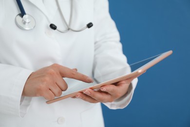 Photo of Doctor with tablet on blue background, closeup view