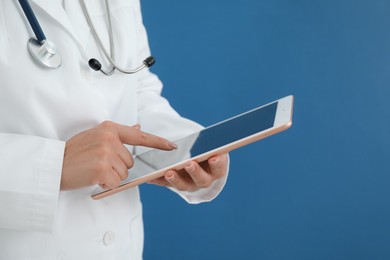 Photo of Doctor with tablet on blue background, closeup view