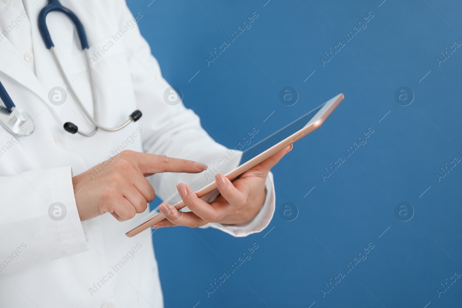 Photo of Doctor with tablet on blue background, closeup view