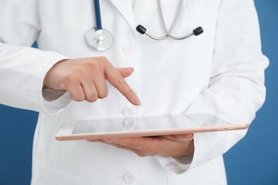 Photo of Doctor with tablet on blue background, closeup view