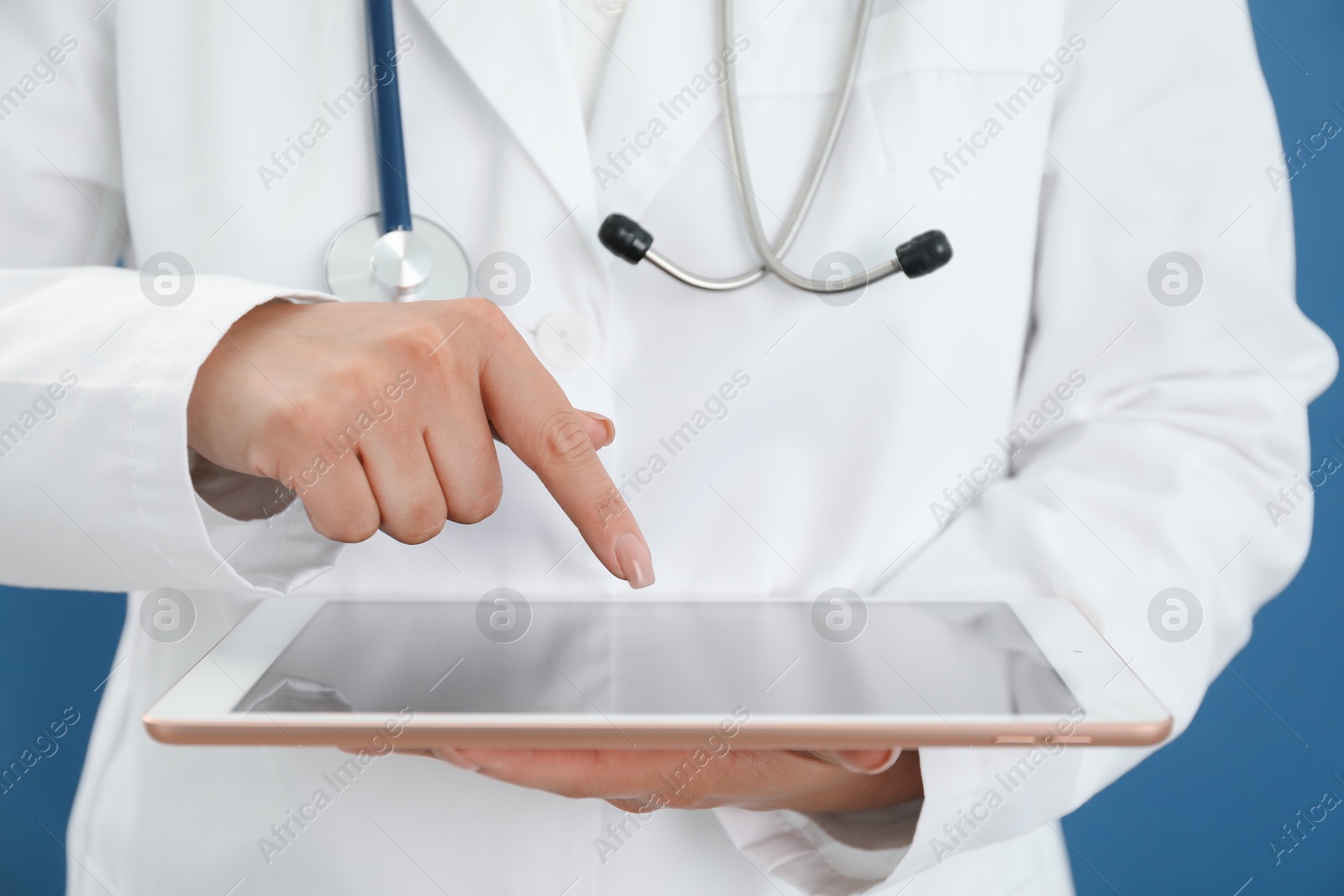 Photo of Doctor with tablet on blue background, closeup view