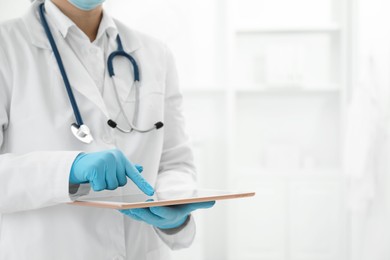 Photo of Doctor with tablet in clinic, closeup view. Space for text