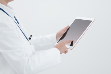 Photo of Doctor with tablet on white background, closeup view