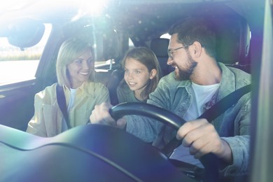 Photo of Happy family enjoying trip together by car, view through windshield