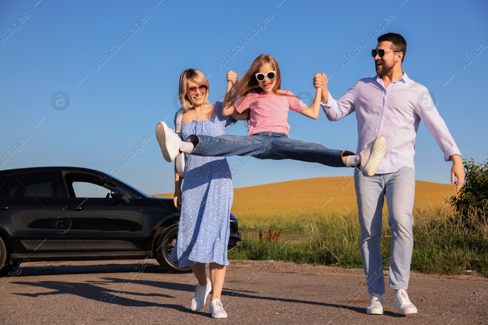 Photo of Parents, their daughter and car outdoors. Family traveling