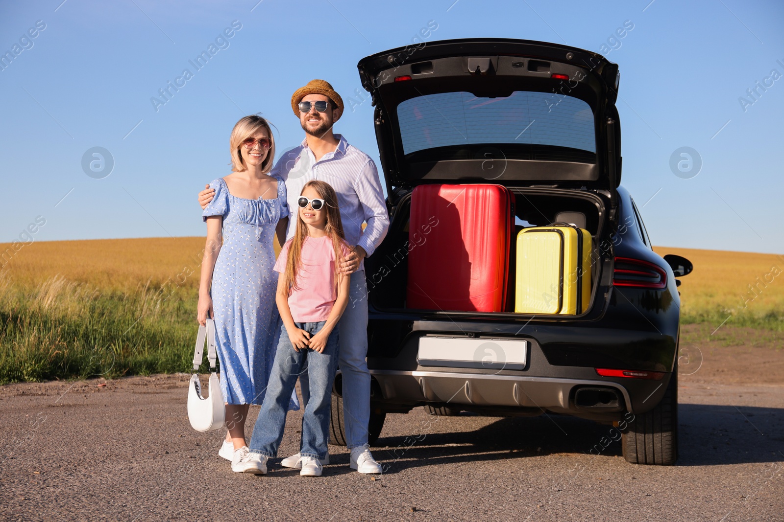 Photo of Happy family near car with suitcases outdoors