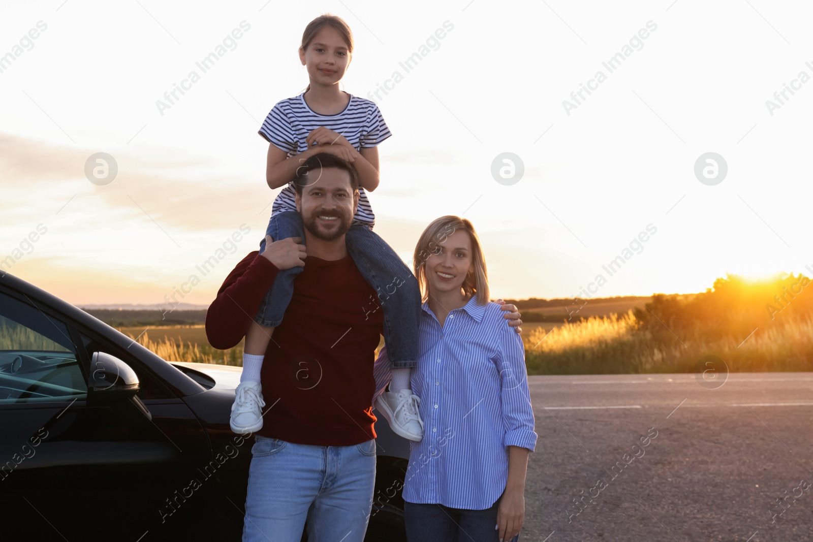 Photo of Happy parents and their daughter near car outdoors, space for text