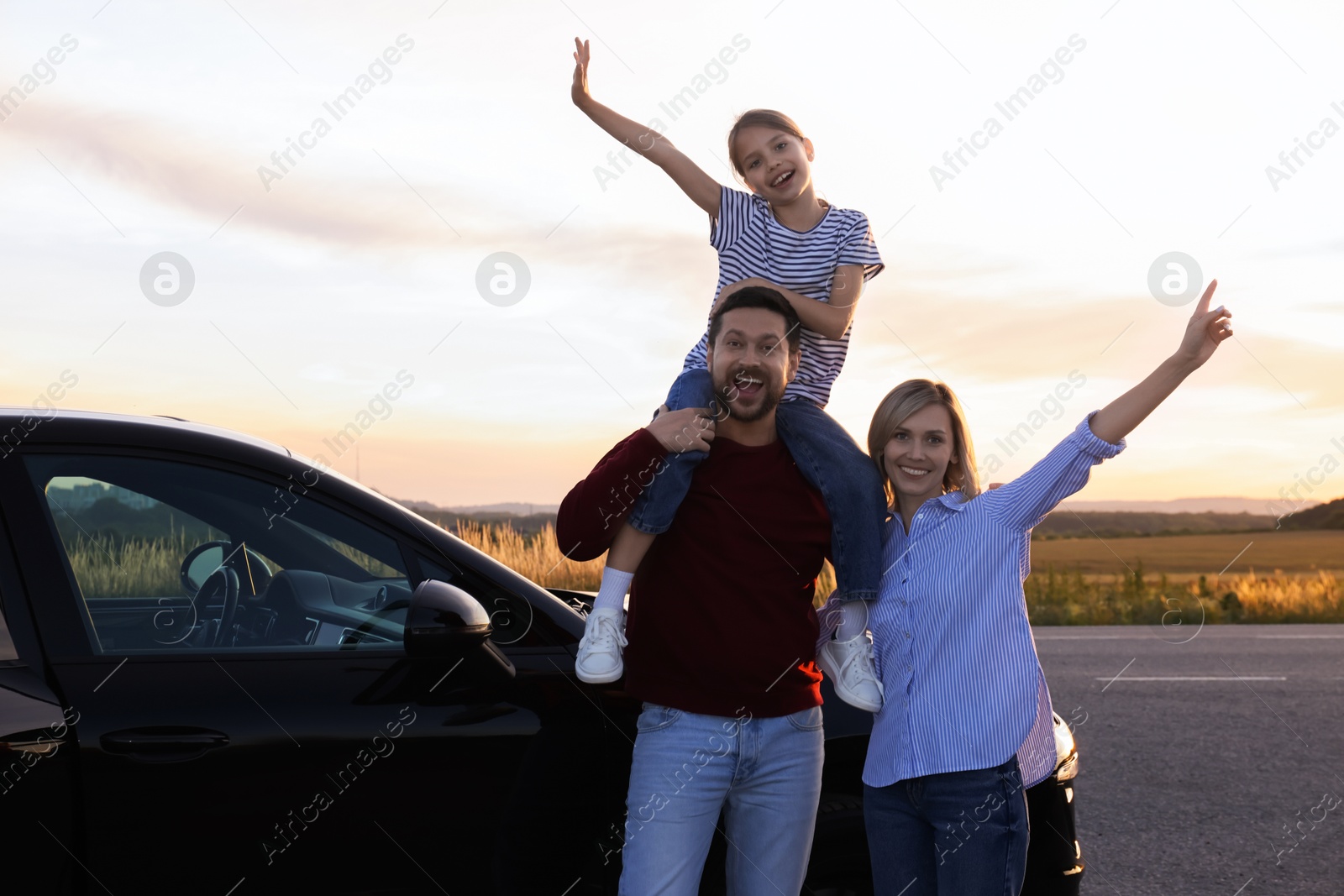 Photo of Happy parents and their daughter near car outdoors