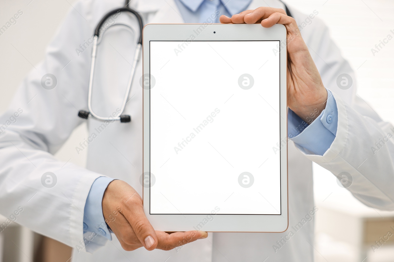 Photo of Doctor showing tablet with blank screen in hospital, selective focus