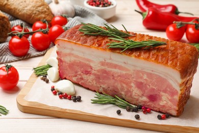 Photo of Piece of raw bacon with spices and cherry tomatoes on white wooden table