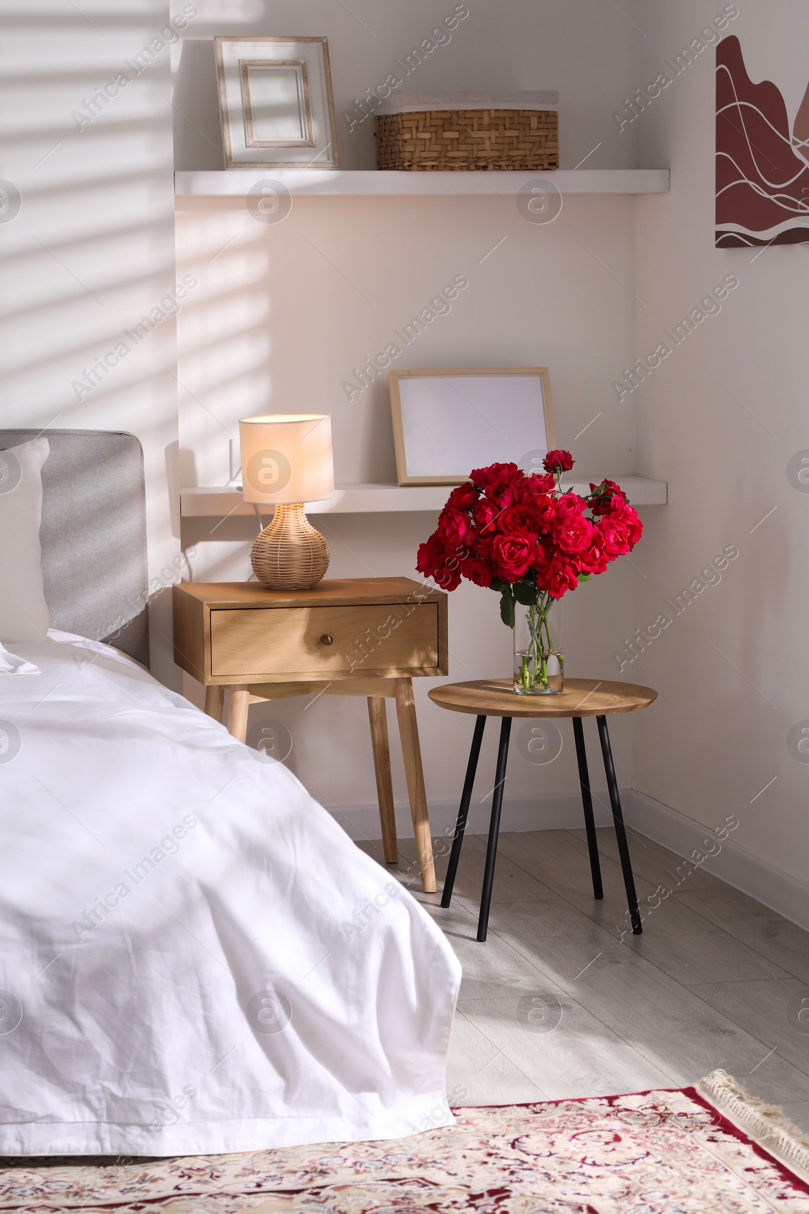 Photo of Nightstand, lamp and decorative elements in bedroom. Interior design