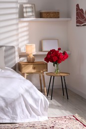 Photo of Nightstand, lamp and decorative elements in bedroom. Interior design