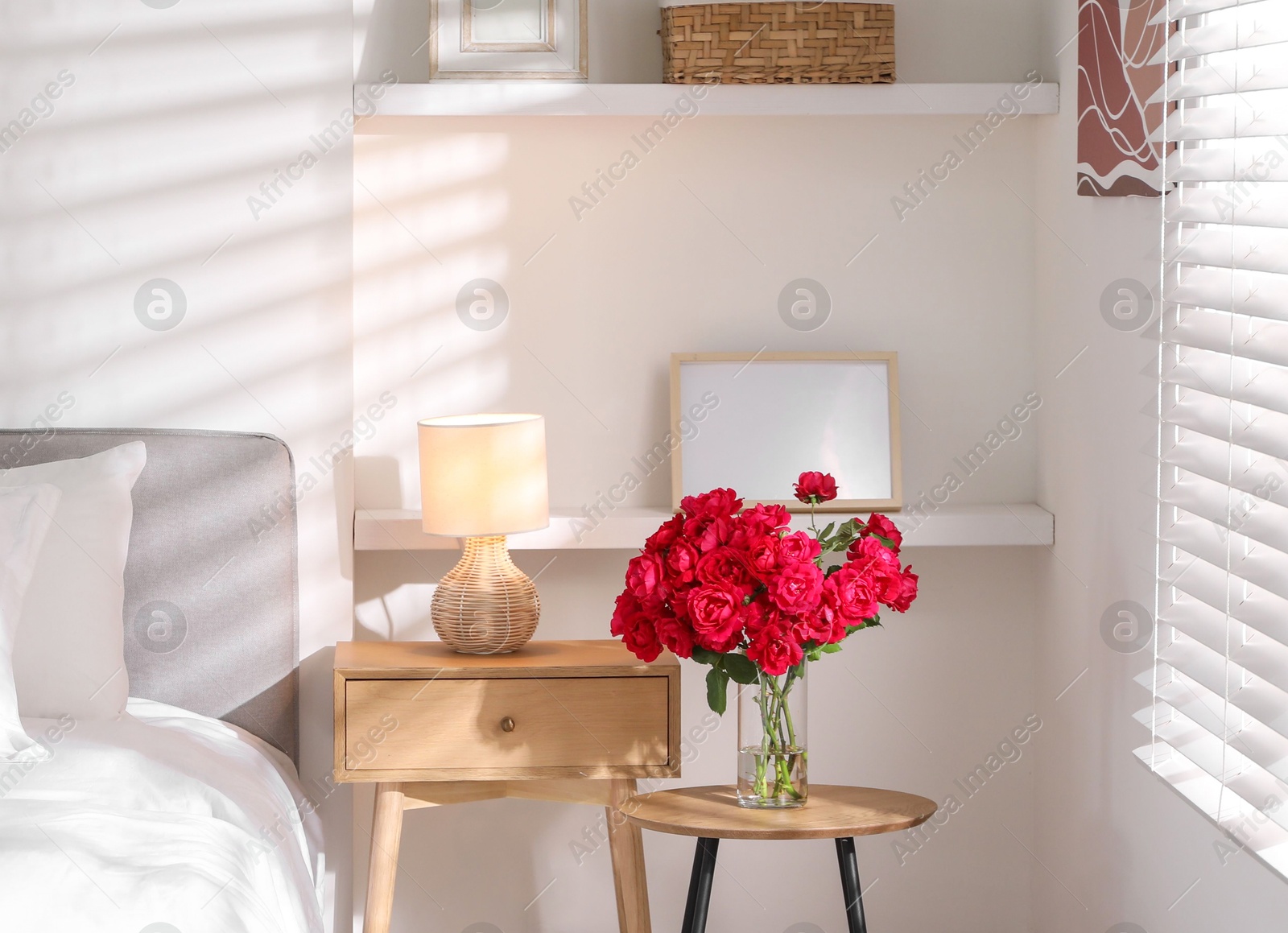 Photo of Nightstand, lamp and decorative elements in bedroom. Interior design