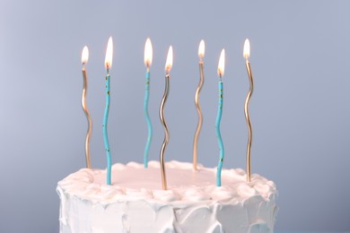 Photo of Tasty Birthday cake with burning candles on gray background, closeup