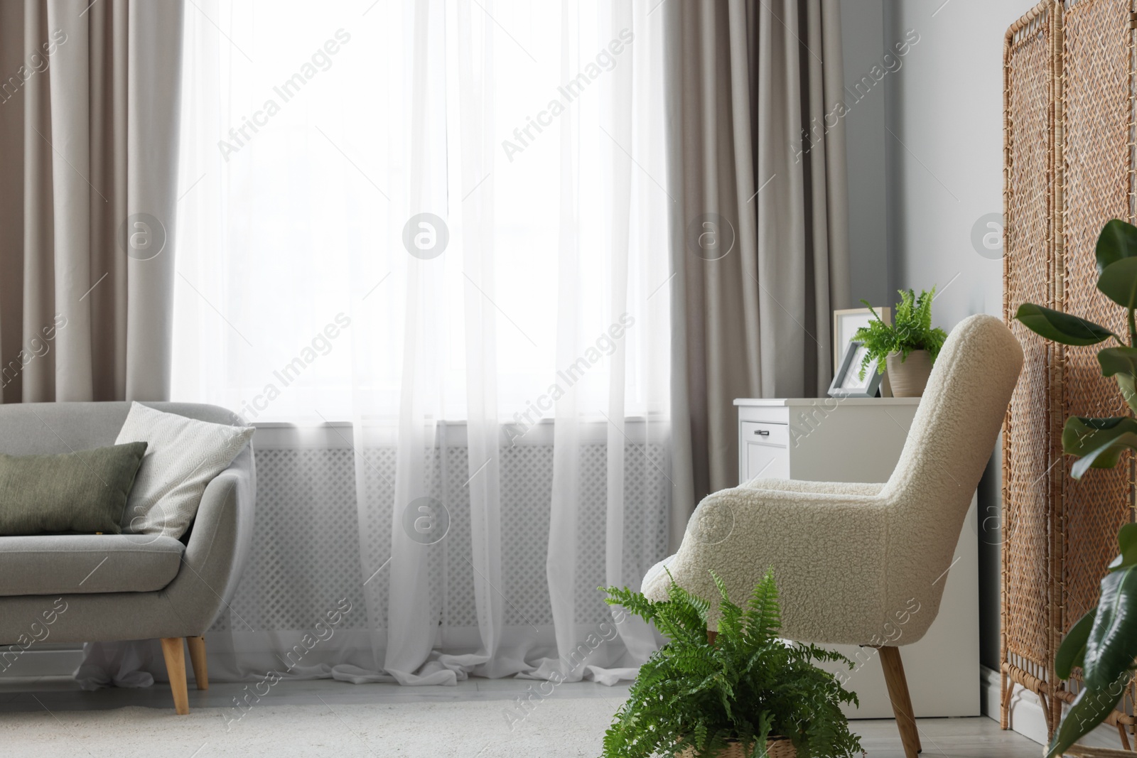 Photo of Stylish furniture and elegant curtains in living room. Interior design