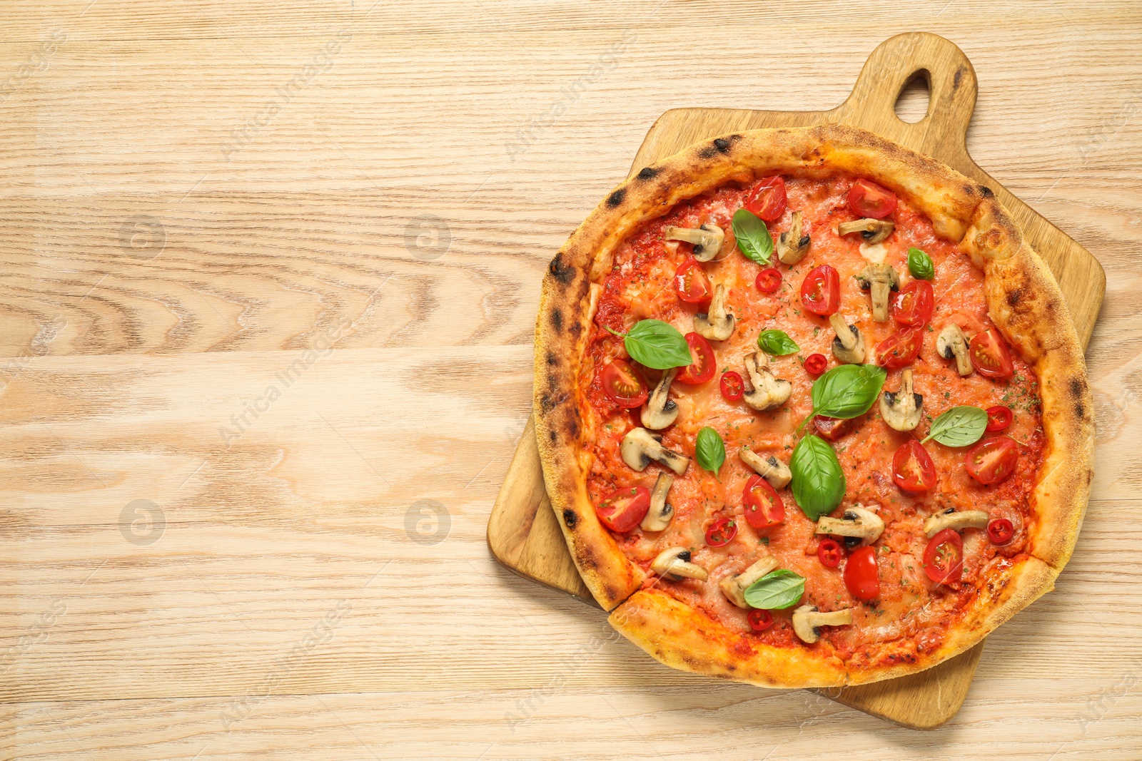 Photo of Delicious pizza with tomatoes, mushrooms and basil on wooden table, top view. Space for text