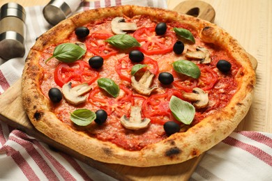 Photo of Delicious pizza with tomatoes, mushrooms, black olives and basil on wooden table, closeup