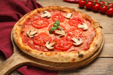 Photo of Delicious pizza with tomatoes, mushrooms and basil on wooden table, closeup