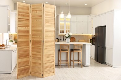 Photo of Stylish kitchen interior with folding screen and table