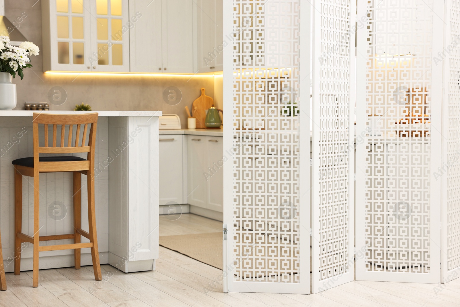 Photo of Stylish kitchen interior with folding screen and table