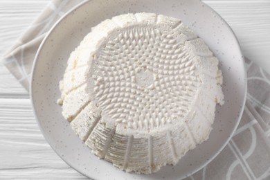 Photo of Tasty ricotta (cream cheese) on white wooden table, top view