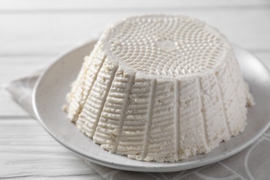 Photo of Tasty ricotta (cream cheese) on white wooden table, closeup