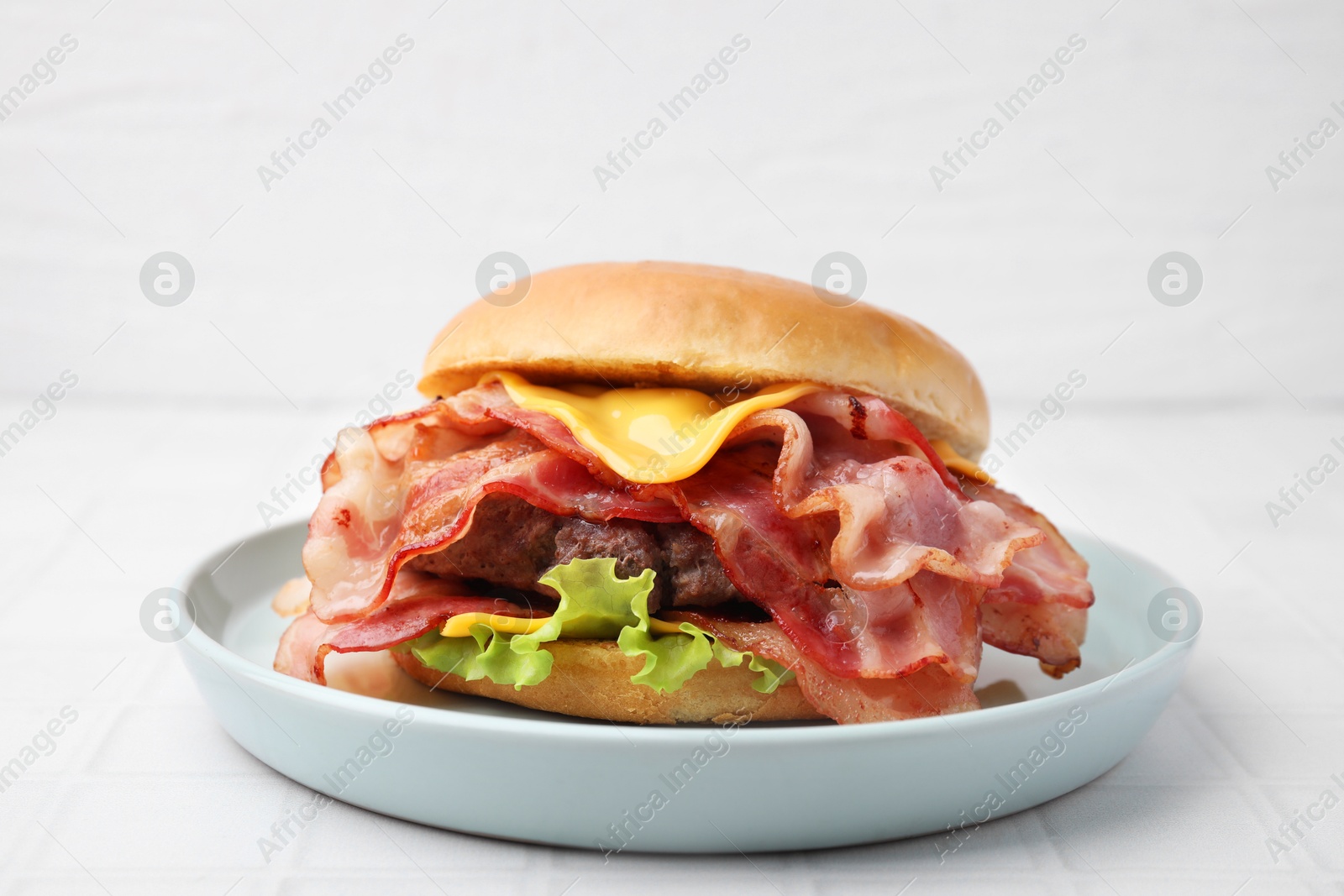 Photo of Delicious burger with bacon, patty and cheese on white tiled table