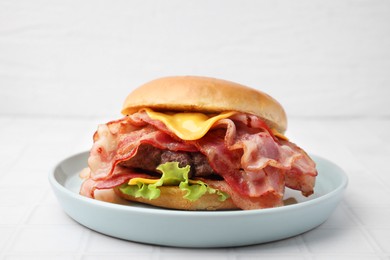 Photo of Delicious burger with bacon, patty and cheese on white tiled table