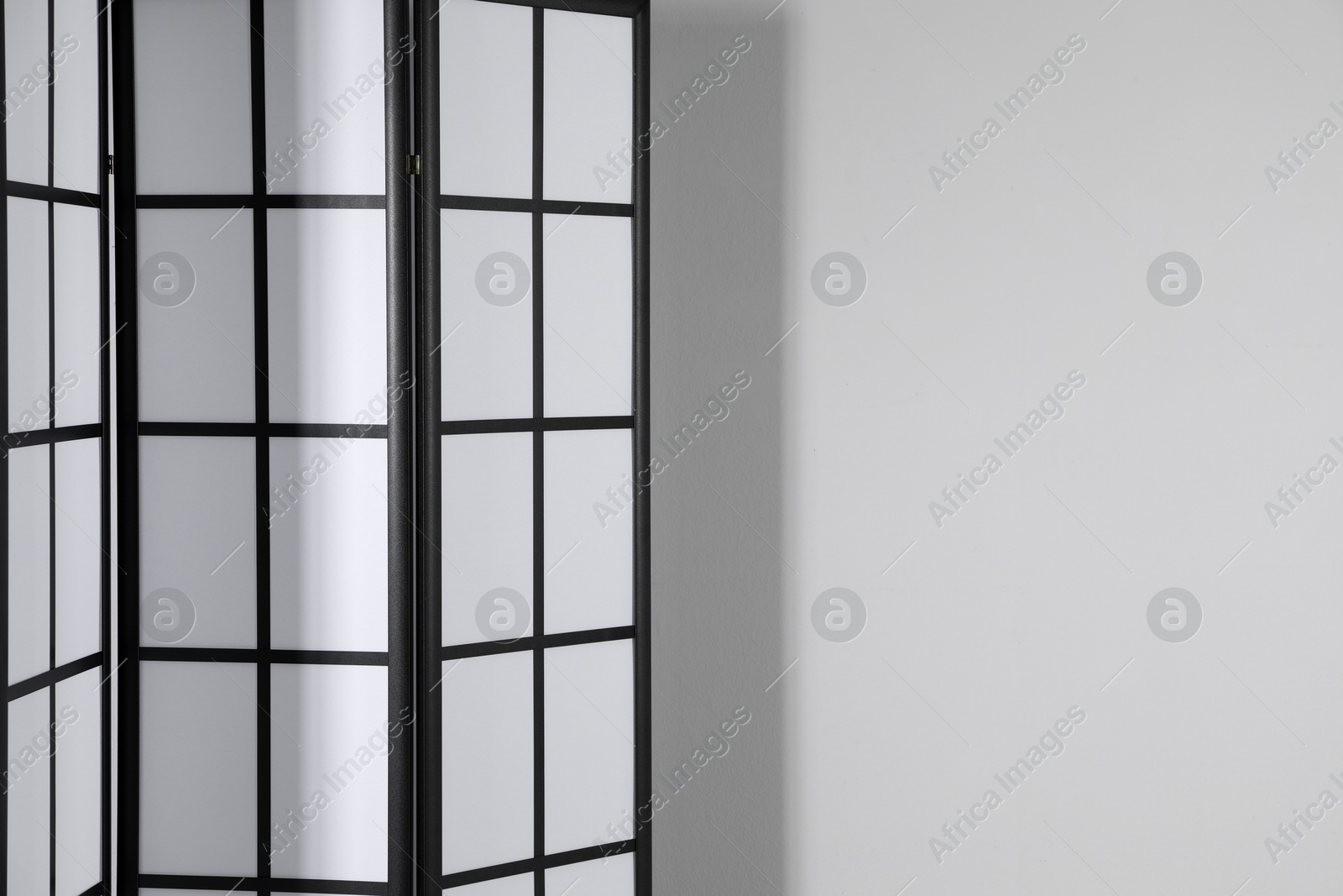 Photo of One folding screen near white wall indoors, space for text