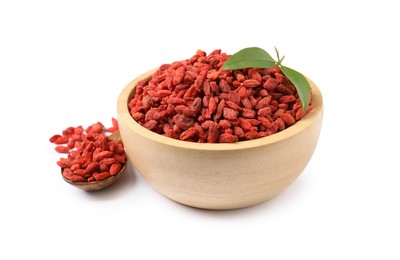 Dried goji berries in bowl, leaves and spoon isolated on white