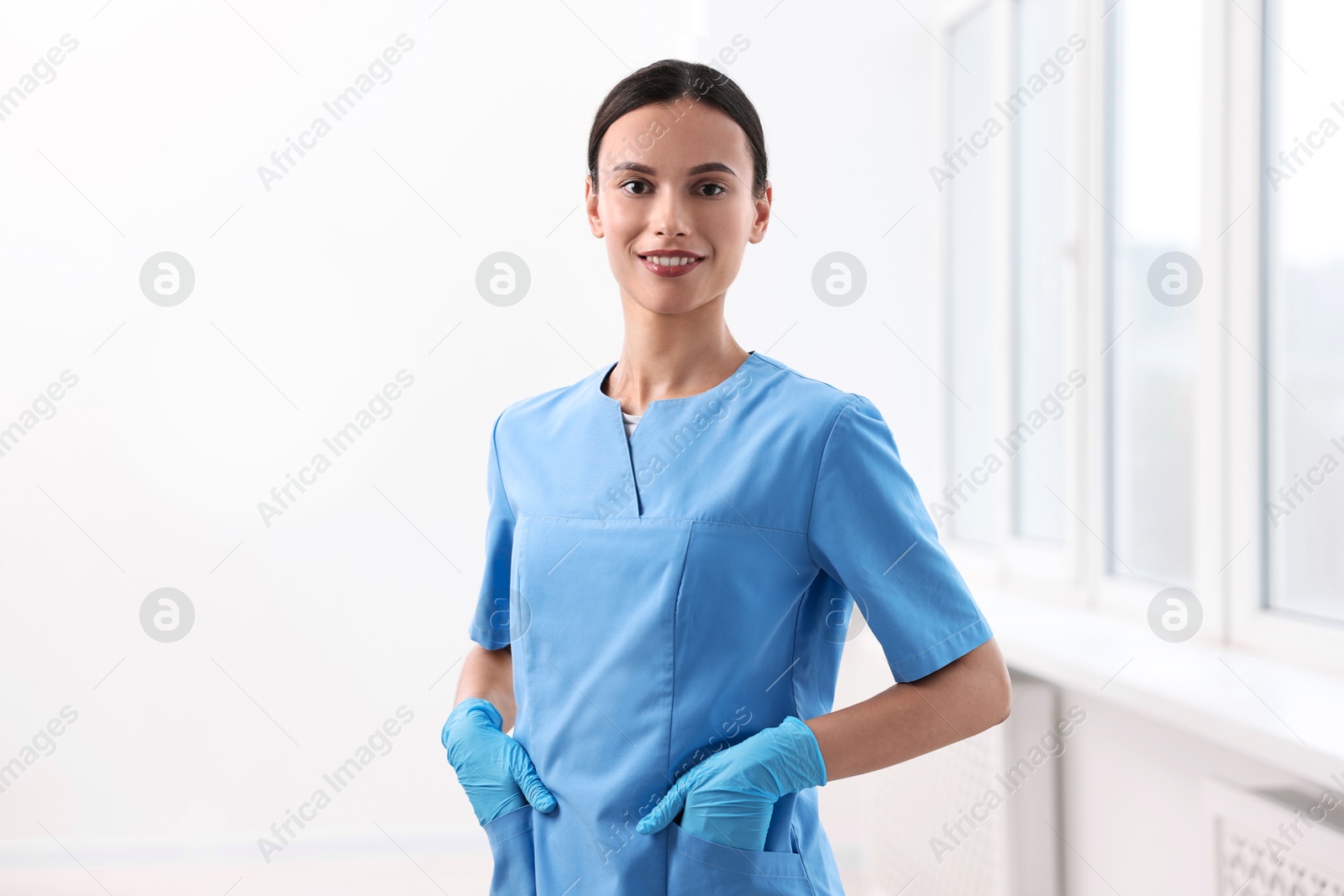 Photo of Portrait of smiling nurse wearing uniform in clinic