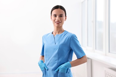 Photo of Portrait of smiling nurse wearing uniform in clinic