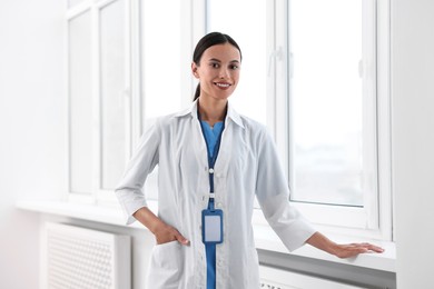 Portrait of smiling nurse near window in clinic