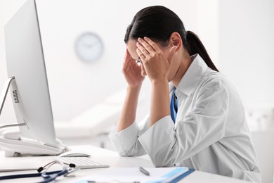 Tired nurse sitting at table in clinic