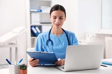 Smiling nurse working at table in clinic