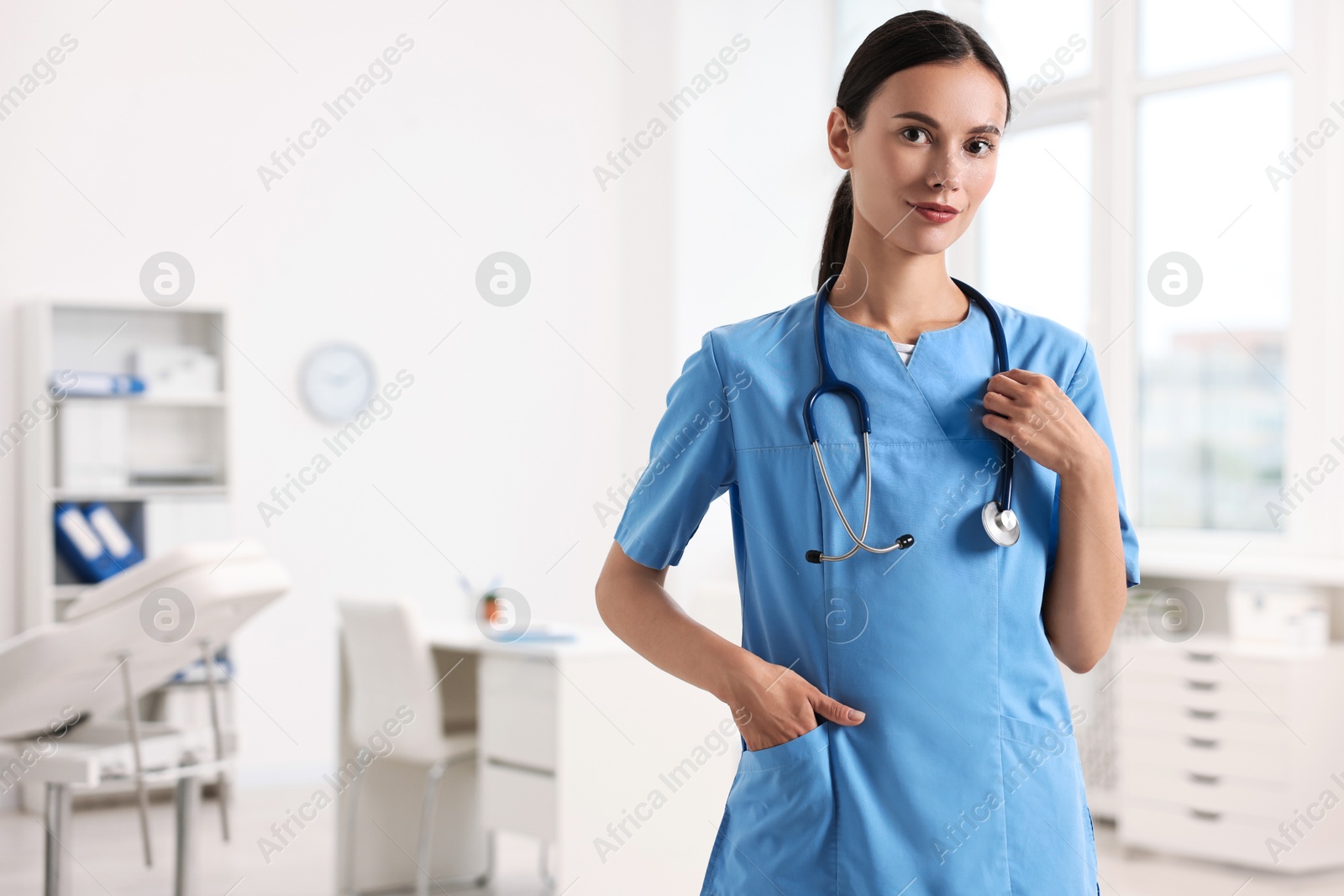 Photo of Portrait of beautiful nurse in clinic. Space for text