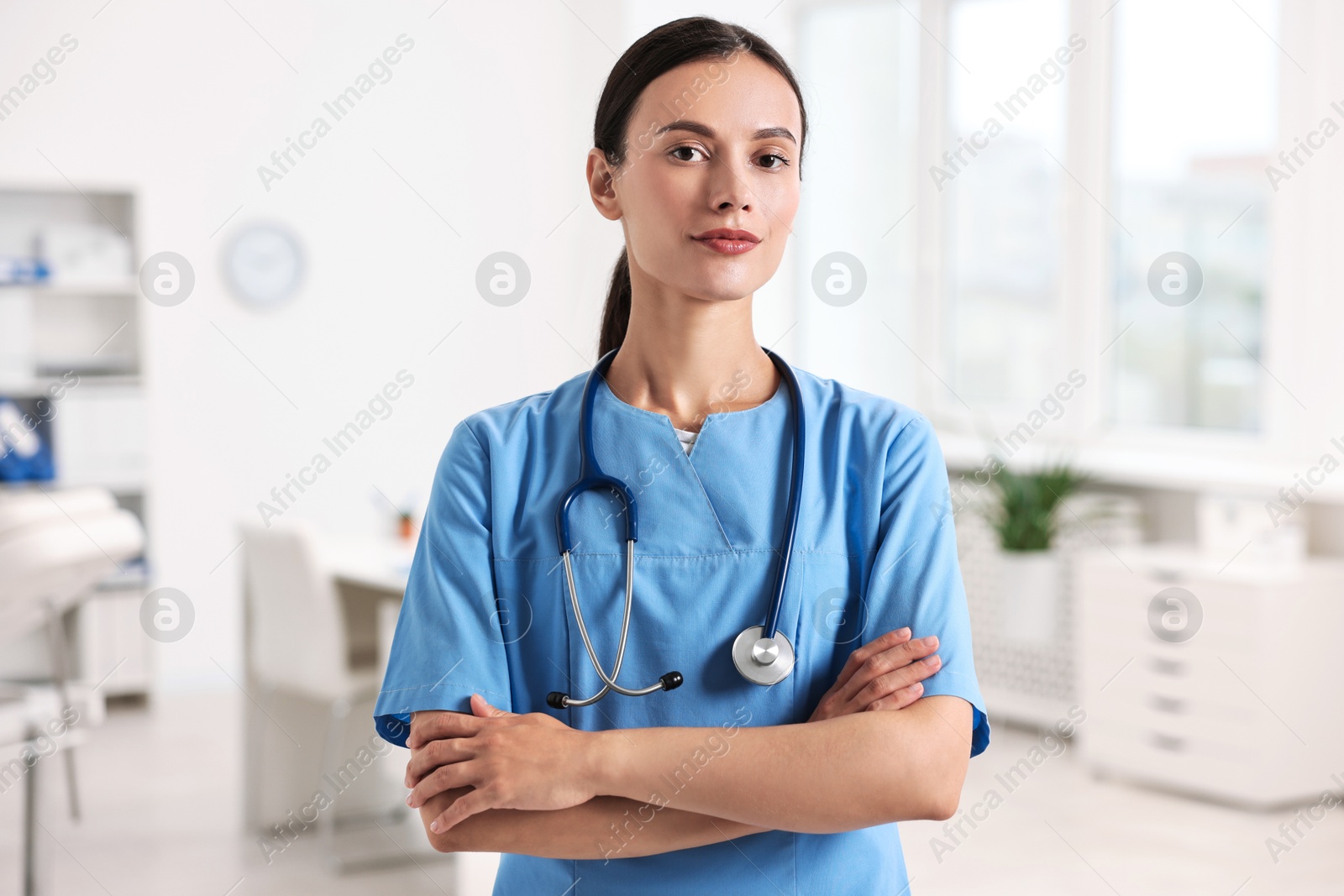 Photo of Beautiful nurse with crossed arms in clinic