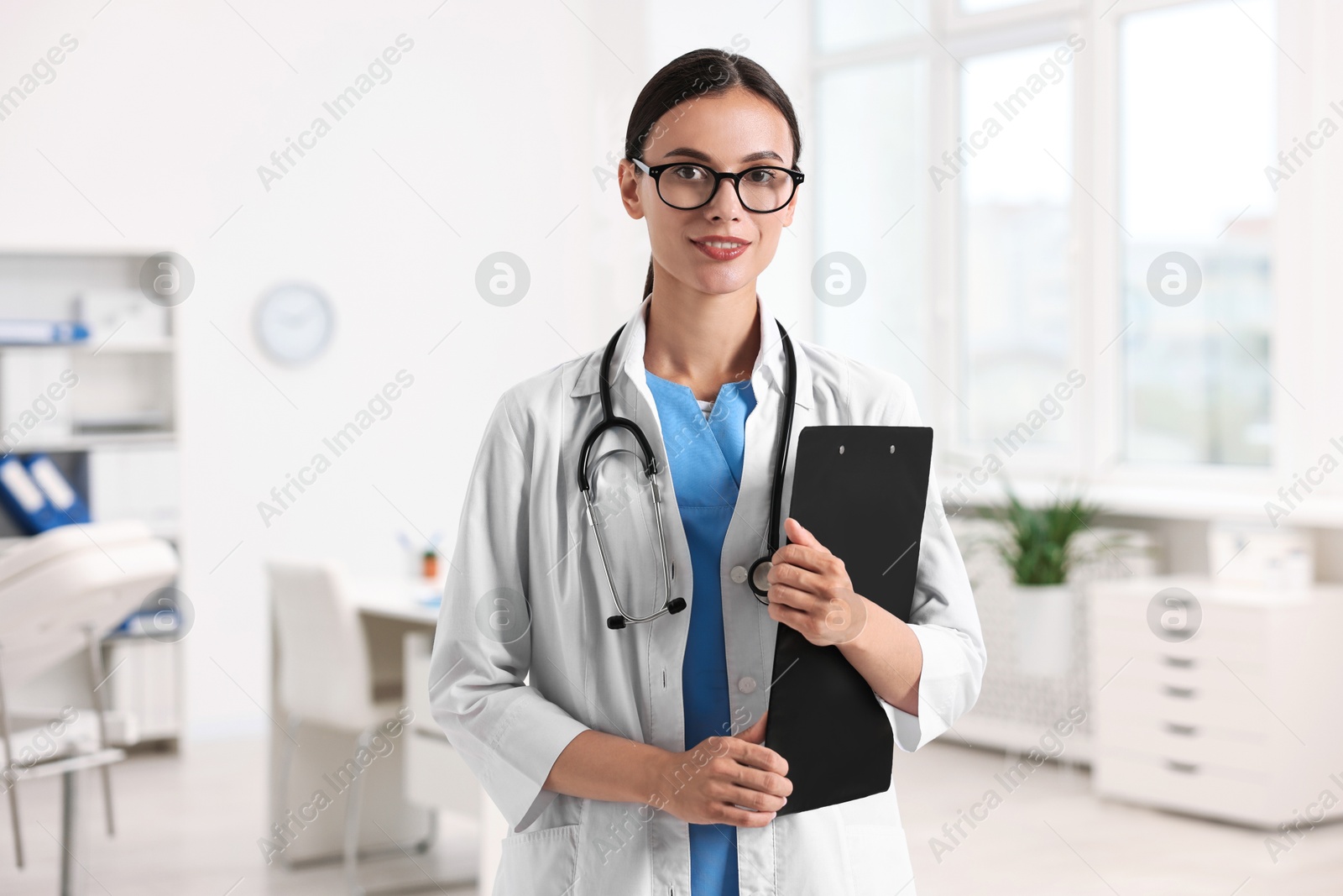 Photo of Portrait of smiling nurse with clipboard in clinic