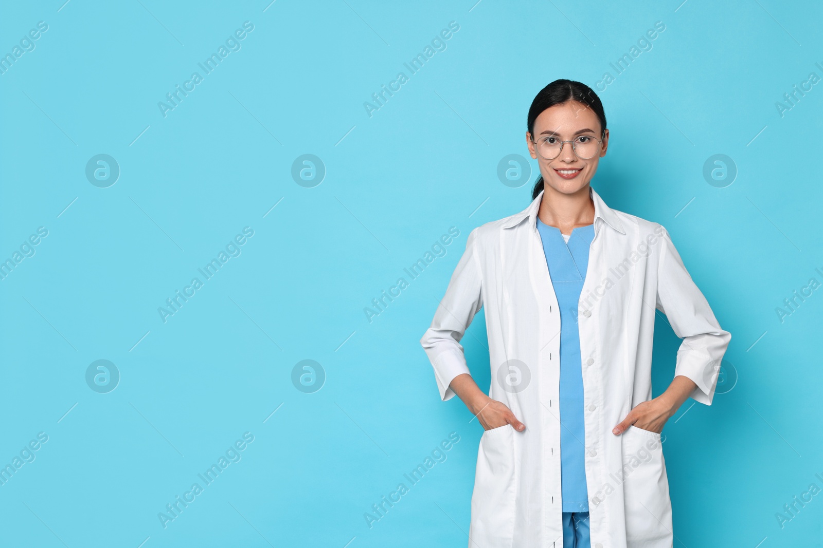 Photo of Smiling nurse on light blue background. Space for text