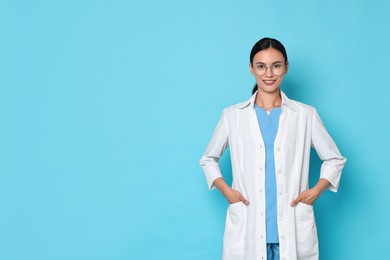 Photo of Smiling nurse on light blue background. Space for text