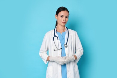 Photo of Beautiful nurse in uniform on light blue background