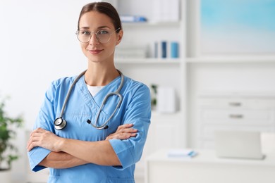 Nurse in medical uniform with stethoscope indoors, space for text