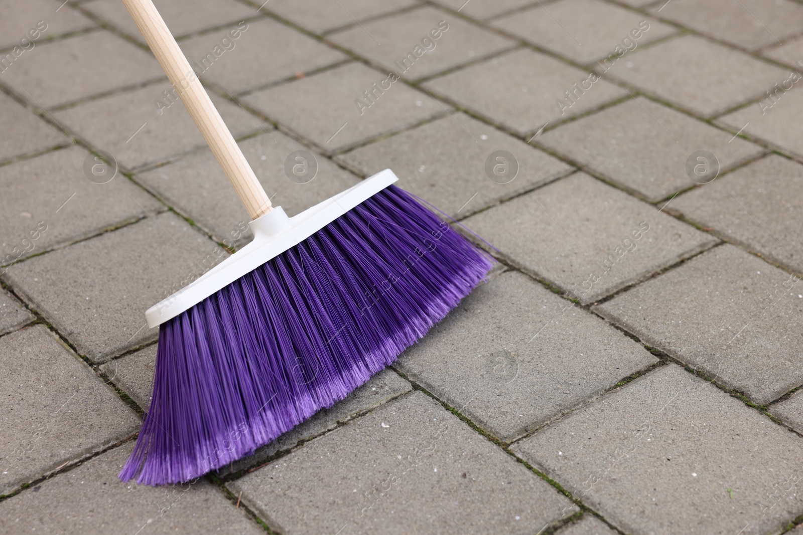 Photo of One bright cleaning broom on pavement outdoors