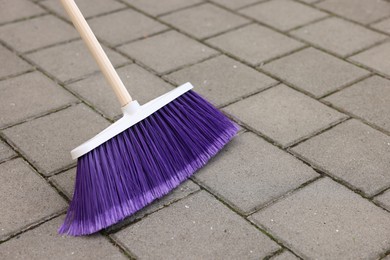 One bright cleaning broom on pavement outdoors