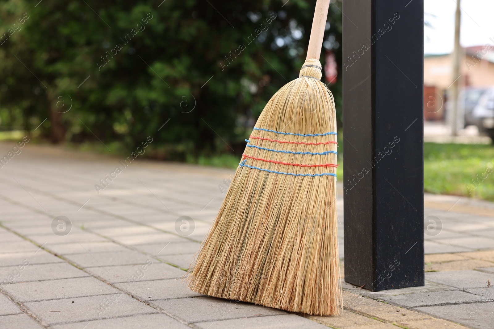 Photo of One corn straw broom on pavement outdoors