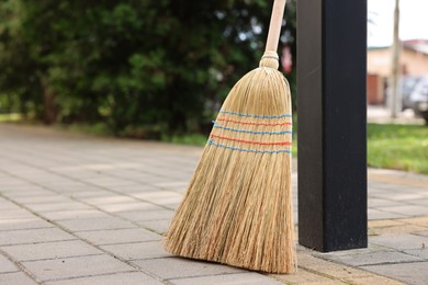 Photo of One corn straw broom on pavement outdoors