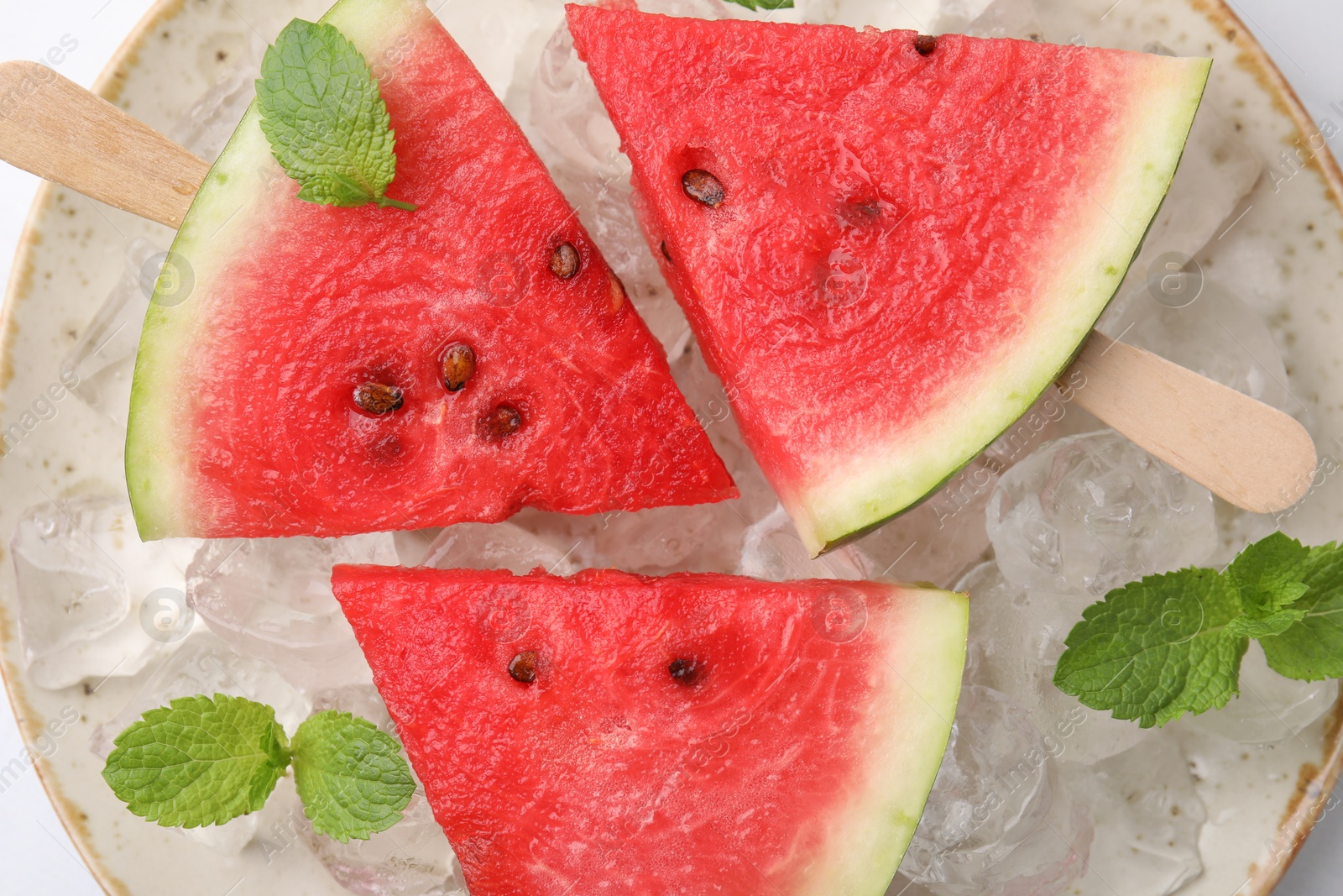 Photo of Pieces of tasty watermelon, ice cubes and mint on table, top view