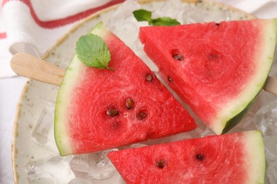 Photo of Pieces of tasty watermelon, ice cubes and mint on table, top view