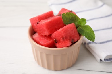 Photo of Pieces of tasty watermelon and mint in bowl on white table, closeup